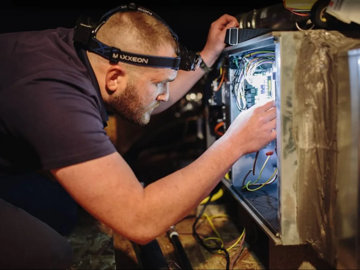 Next Phase technician diagnosing an HVAC system